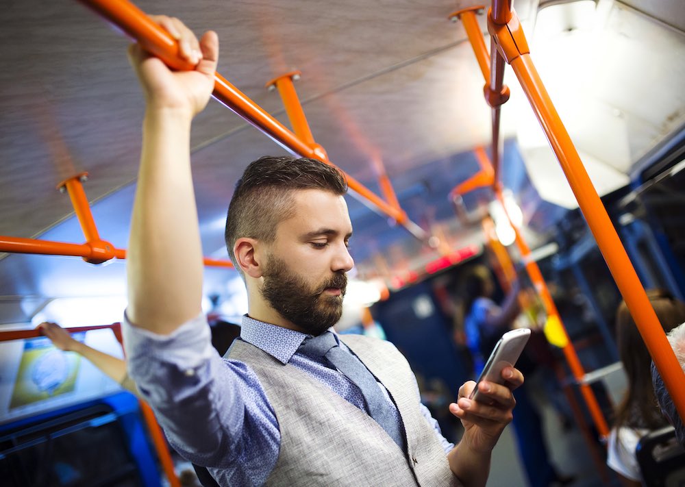 Man on tram looking at his smartphone